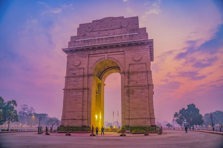The India Gate war memorial in New Delhi under a vibrant pink sky The India Gate is a war memorial located astride the Rajpath,: Delhi holiday packages by OYG H