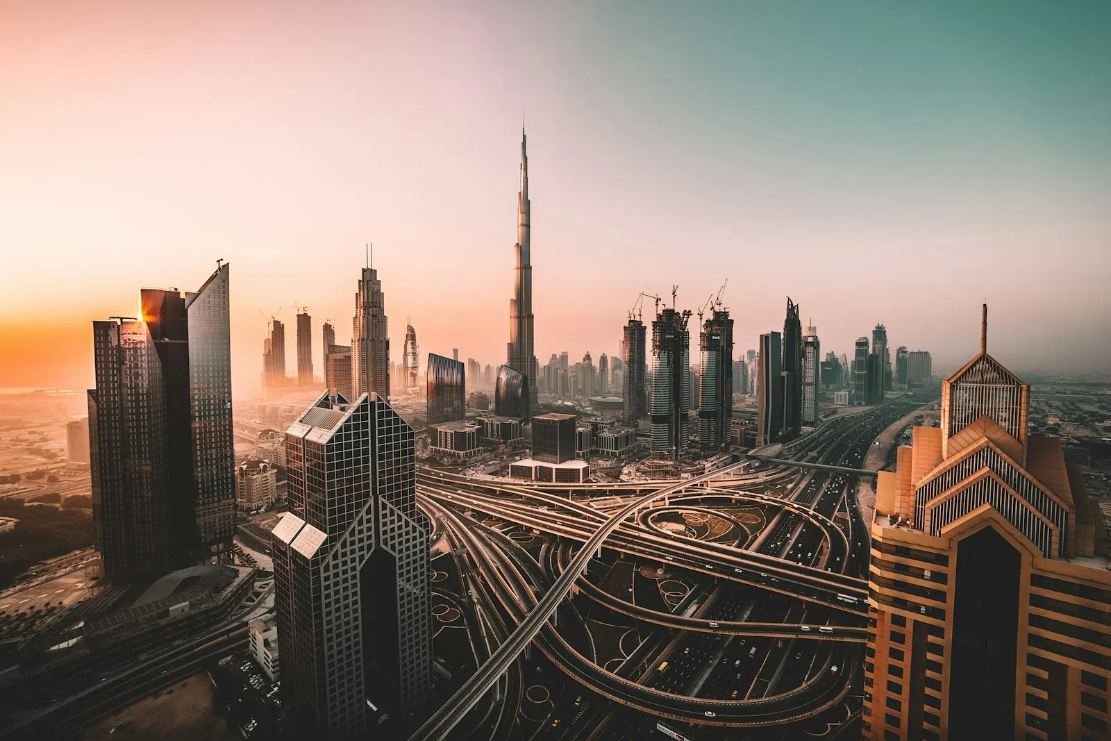 The Burj Khalifa and skyscrapers above a multi-level highway interchange in Dubai Sunrise shot of Downtown Dubai and Burj Khalifa: Dubai and the UAE holiday pac