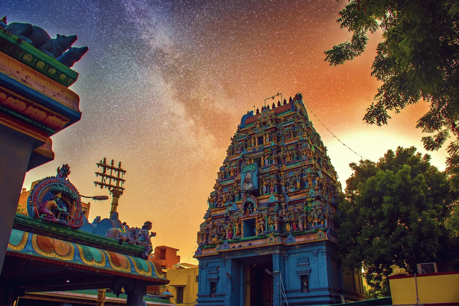 A colorful Hindu temple tower beneath a starry night sky with orange light Temple, Tradition, goodvibes, love, peace, god, goddes : Madurai and Rameswaram holid