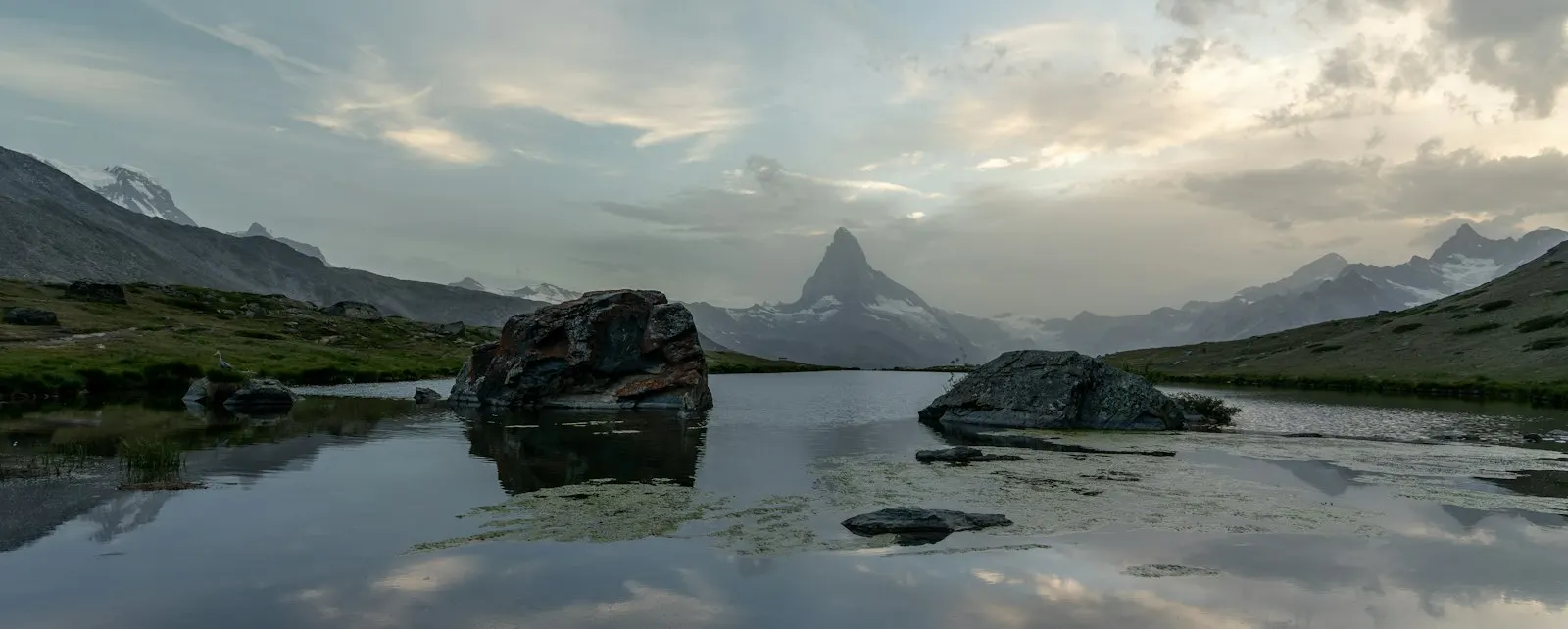 Zermatt mountain lake reflecting cloudy sky: Switzerland holiday packages by OYG Holidays
