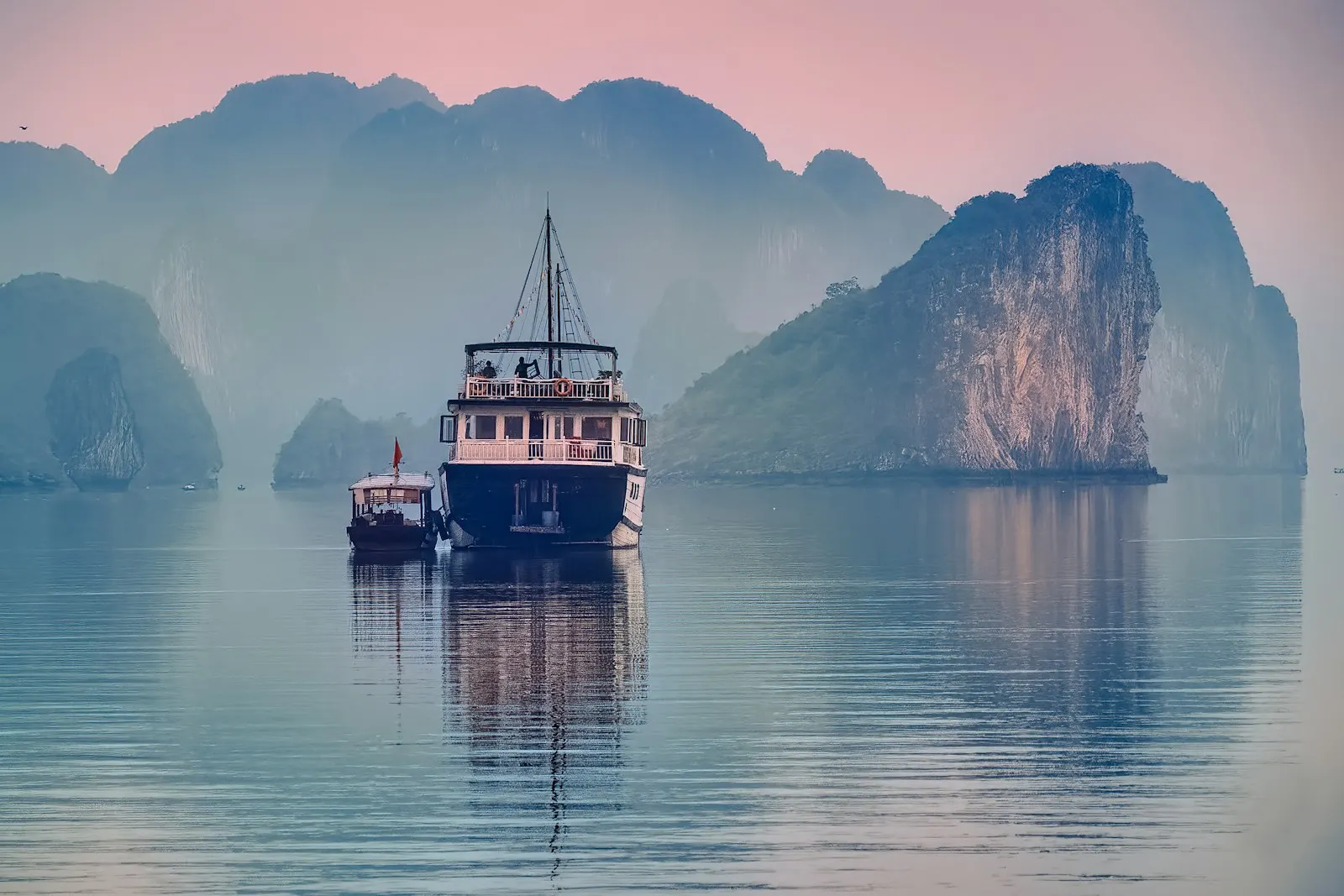 White and black boat on water near mountain during daytime: Vietnam holiday packages by OYG Holidays